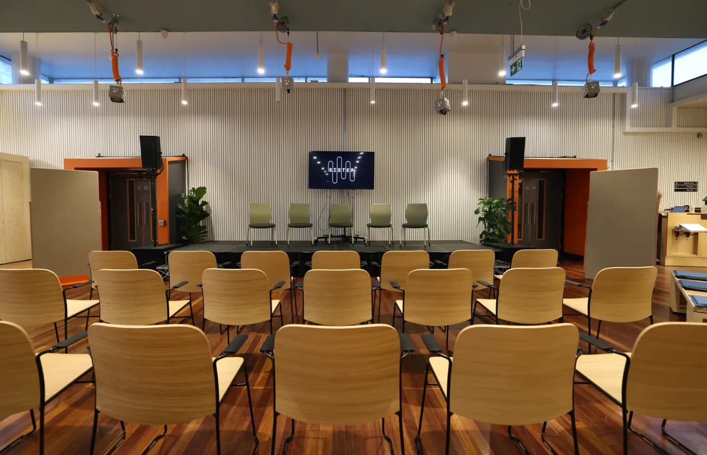 Flexible event space at Sister set up with rows of chairs and a small stage