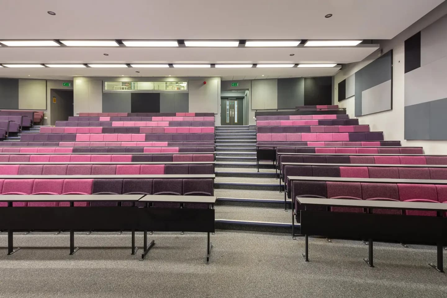 Tiered lecture theatre at Sister with pink and purple seating